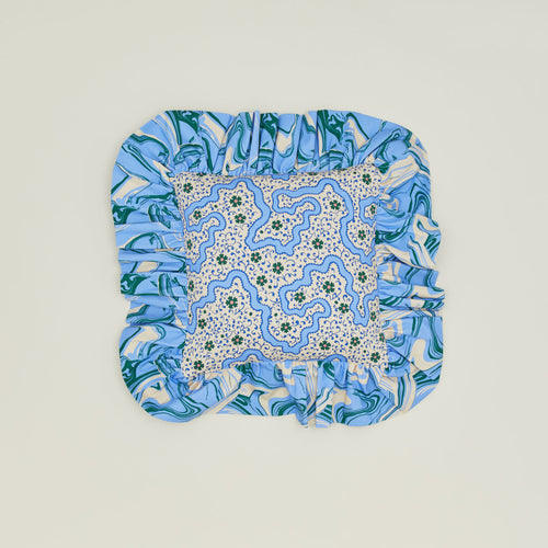 A ruffled floral cushion with a cornflower pattern.