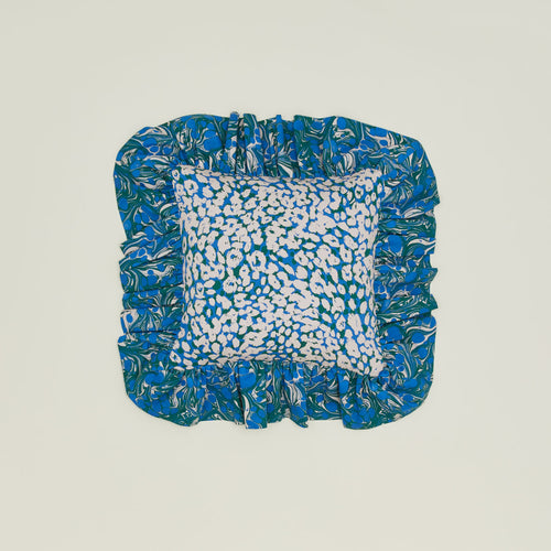 A ruffled floral cushion with an evergreen pattern.