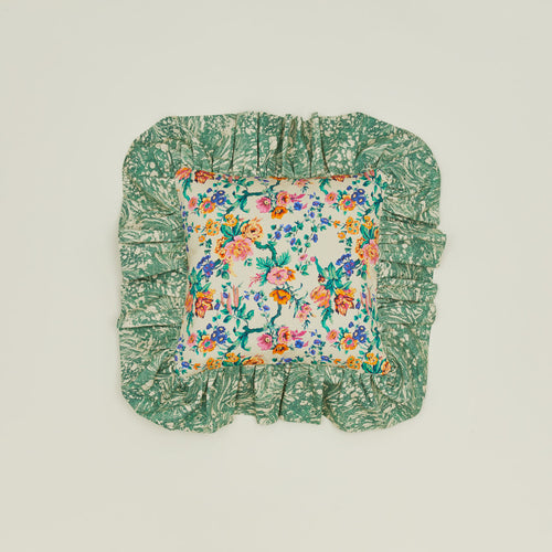 A ruffled floral cushion with a fern pattern.