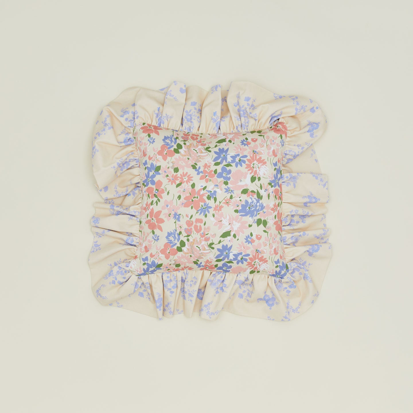 A ruffled floral cushion with a rose pattern.